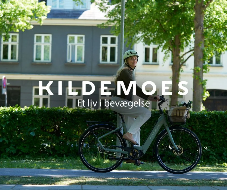 Kvinde med cykelhjelm på Kildemoes dame-elcykel med kurv