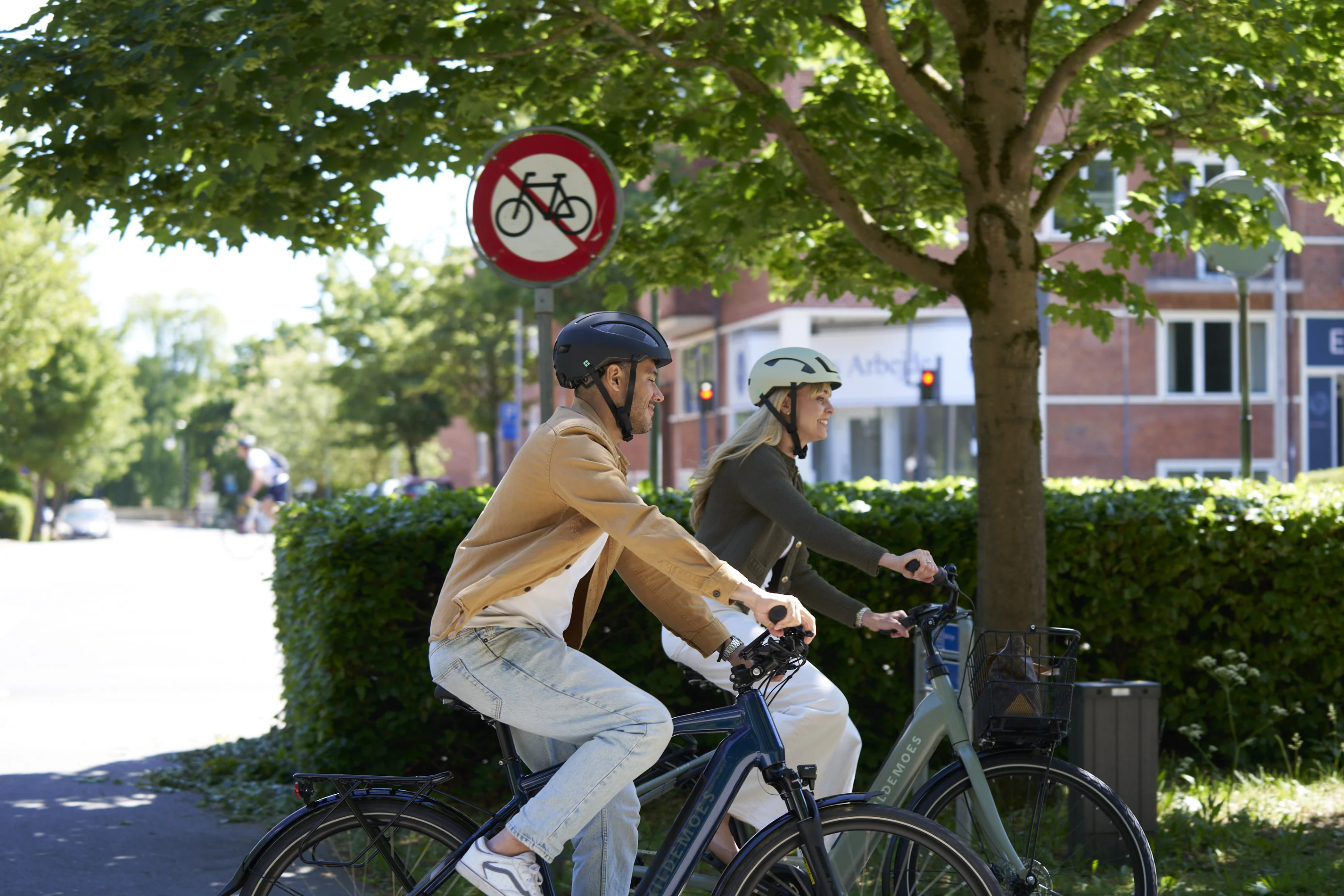 To personer med cykelhjelm på Kildemoes elcykler i byen